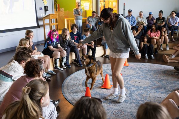 A female student shows skills she taught a dog for a class.