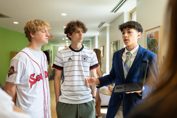 A male student shows his business plan for the It's All Business Endterm