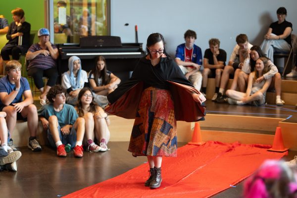 A female student walks the red carpet with her dress she sewed